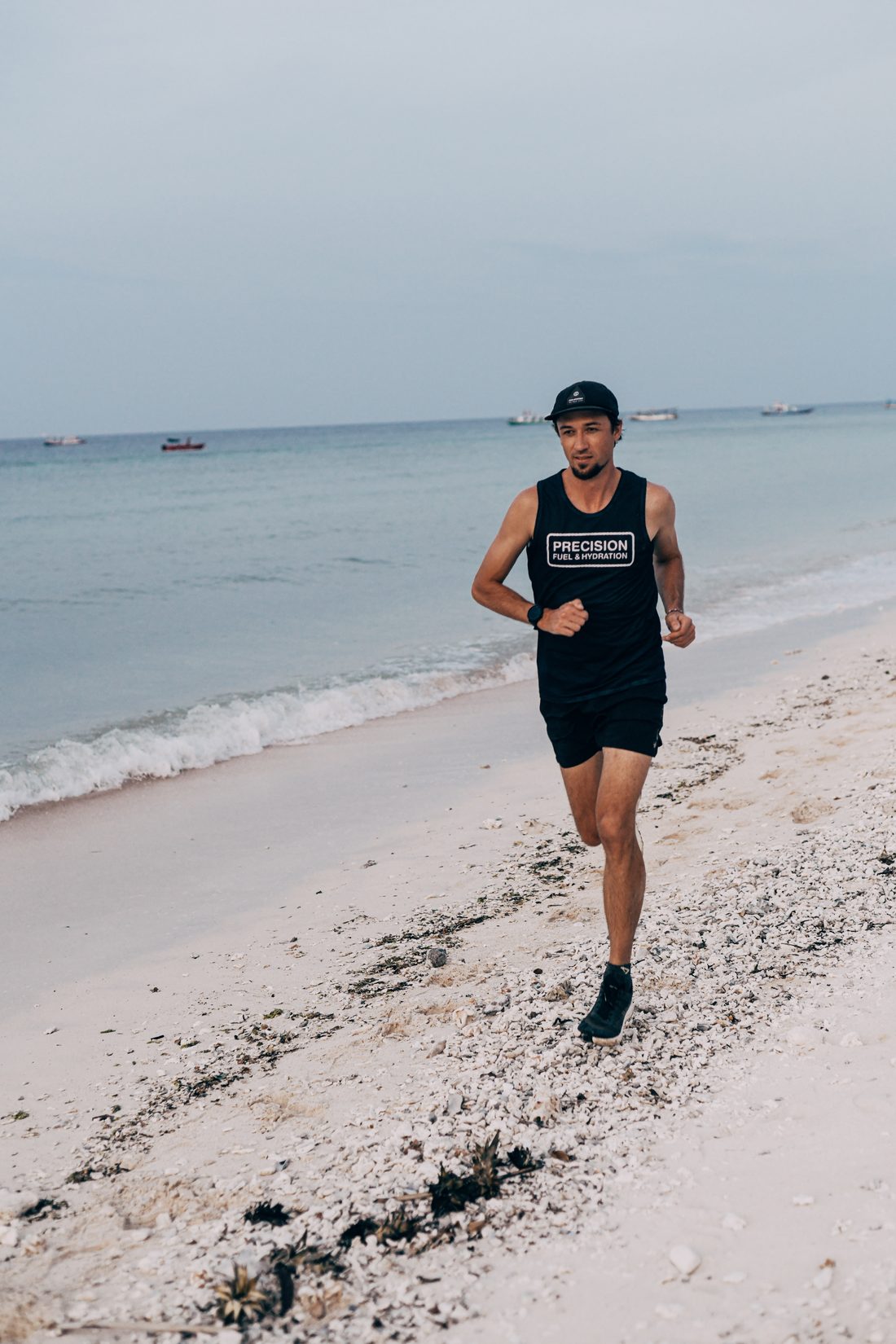 Jack Chamberlain running on a white sand beach in training.