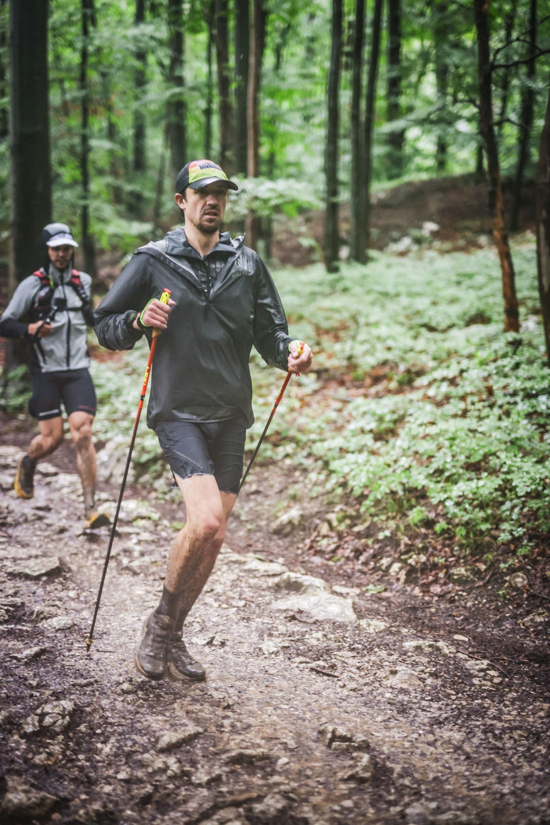 Jack Chamberlain running a steep forest trail in the rain at the Mozart 100 by UTMB.