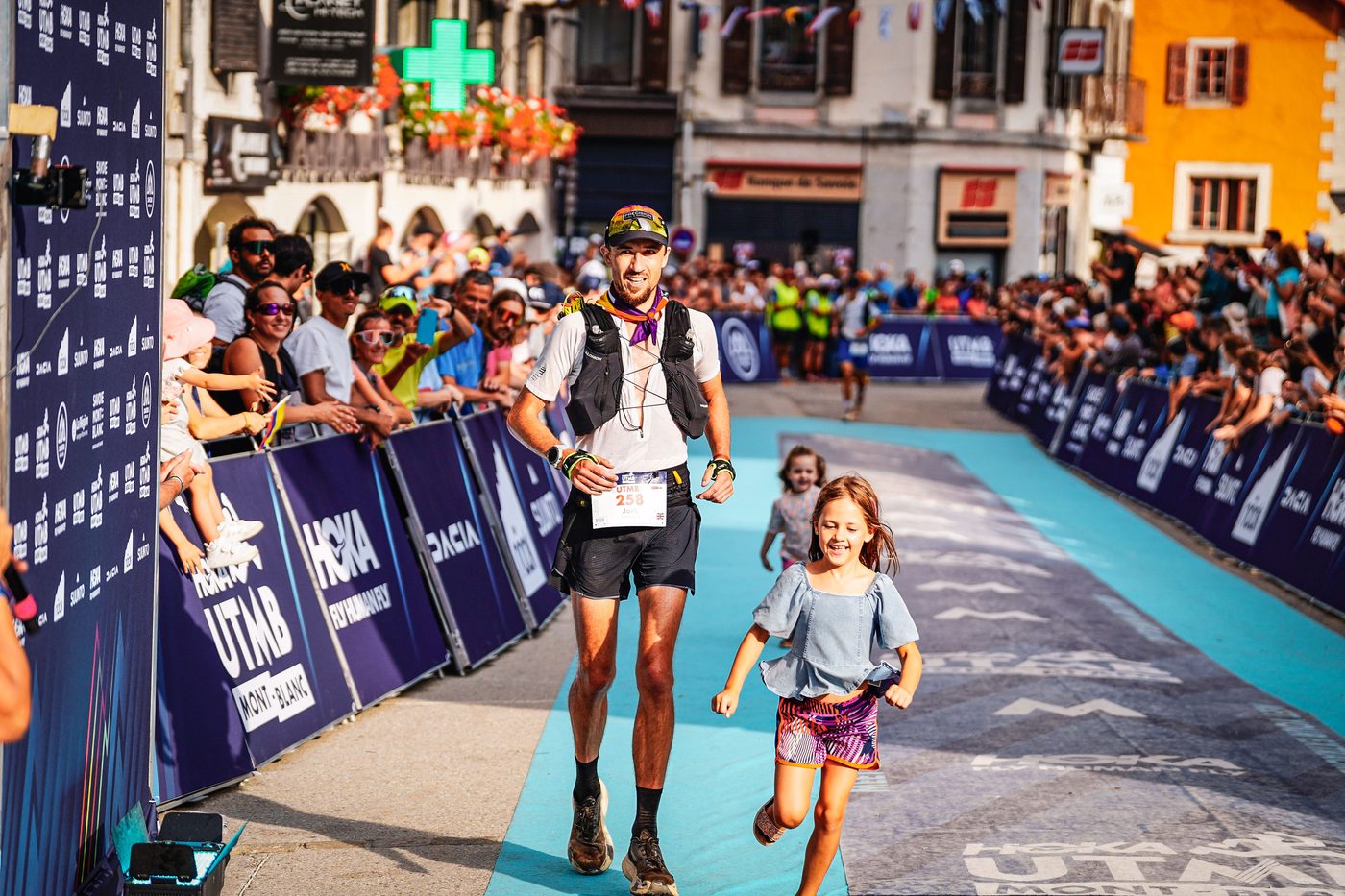 Jack Chamberlain finishing UTMB Mont-Blanc in Chamonix holding hands with his two daughters.