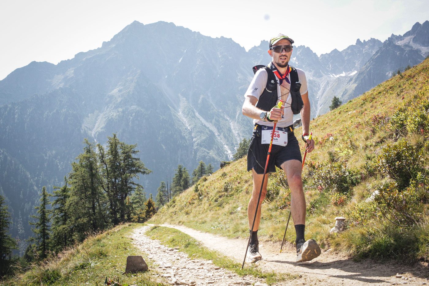 Jack Chamberlain running a high ridge path at UTMB Mont-Blanc with the massif behind him.